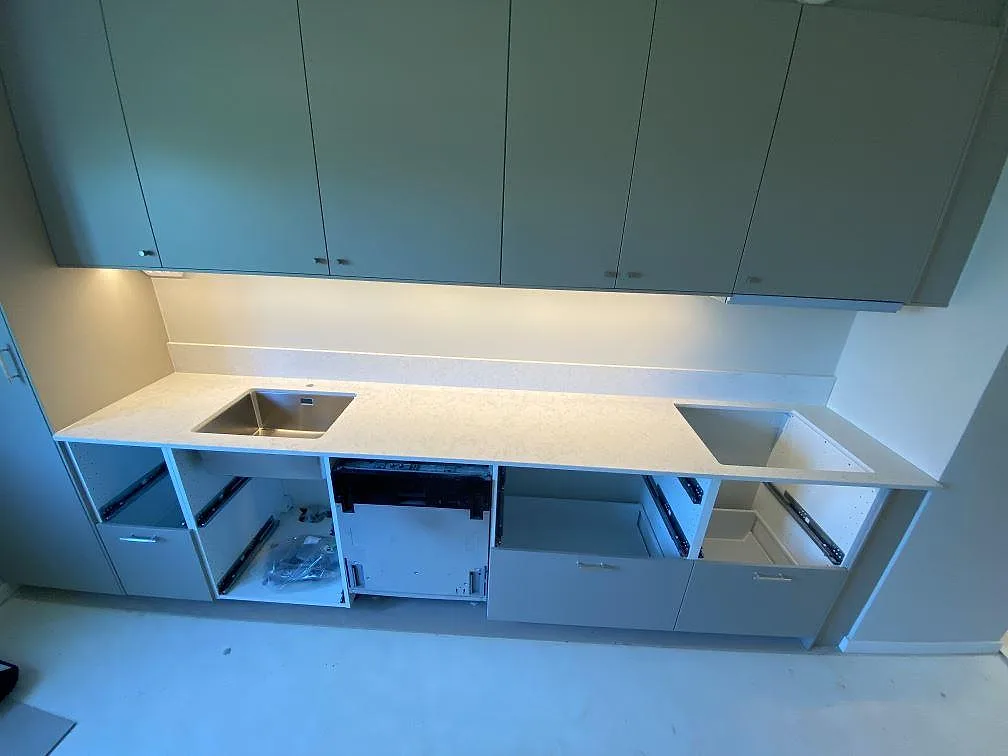 Köksbänkskiva i Technistone Noble Arco, polerad kvartskomposit, med låg stänkkant, diskho och förberett rektangulärt urtag i ett kök i Malmö.