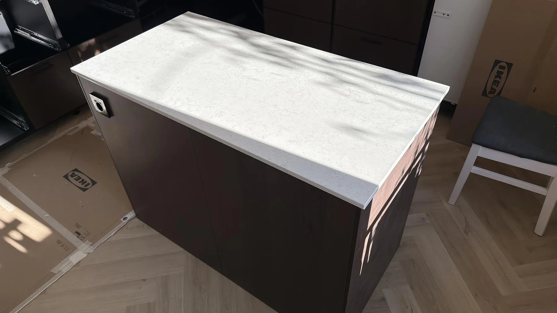 Köksö med bänkskiva i Technistone Noble Arco, polerad ljus kvartskomposit med diskret ådring i Södertälje.