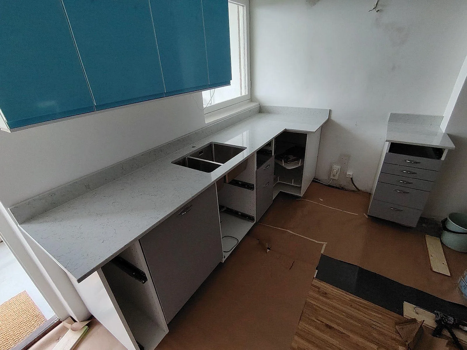 Köksbänkskiva i Technistone Noble Carrara komposit, polerad, med underlimmad rostfri diskho och låg stänkkant i Årsta.