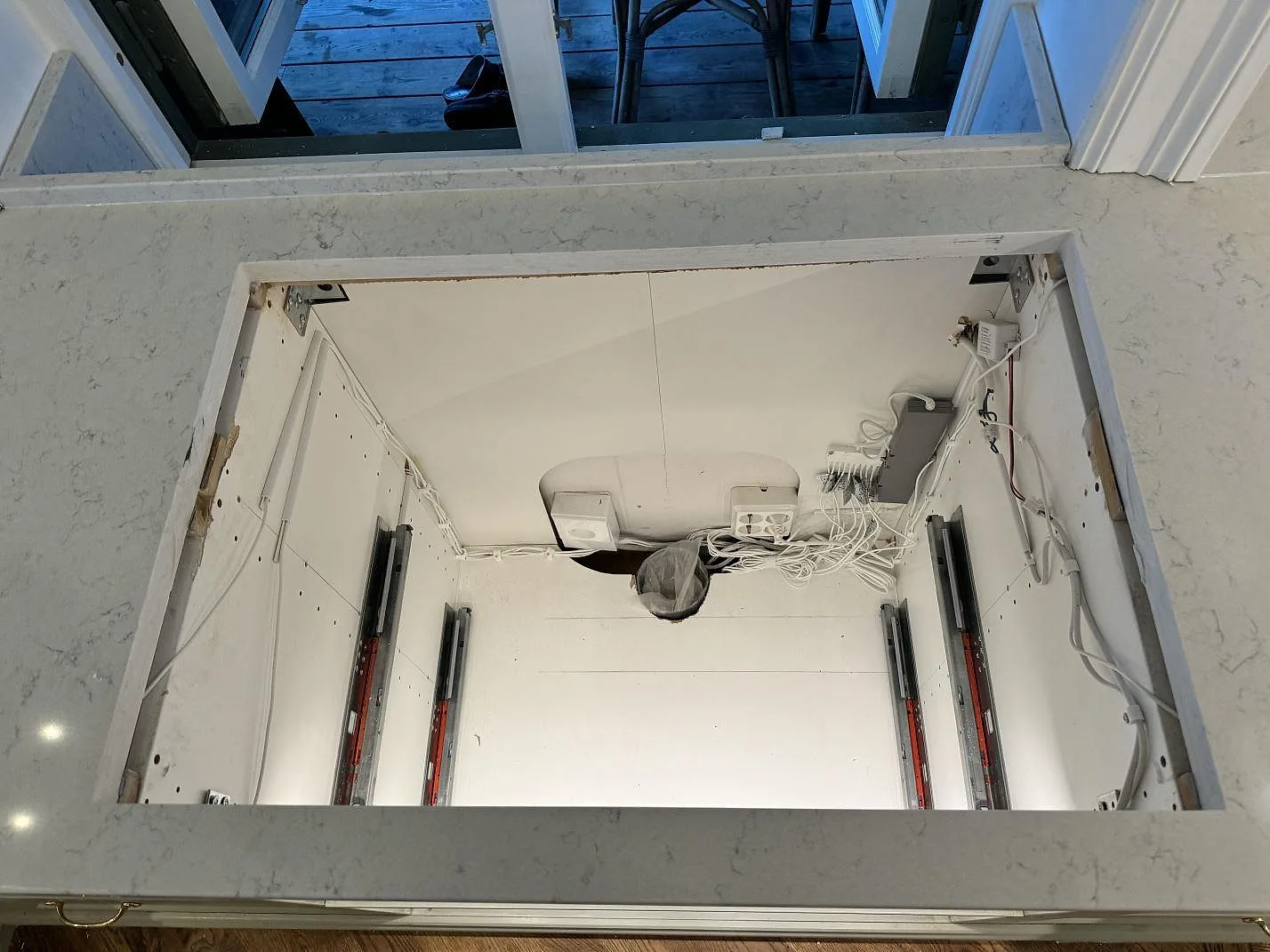 Installationsbild av polerad Technistone Noble Carrara runt tvättställsöppning, med öppen kommod och stenskiva i Göteborg.