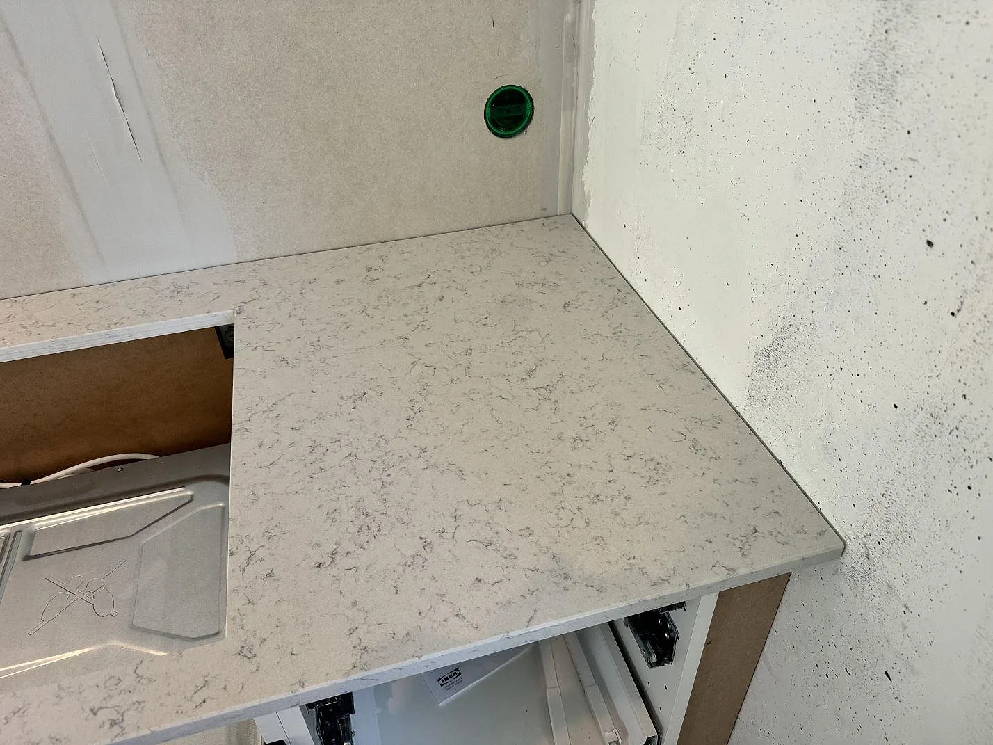 Hörndel av polerad köksbänkskiva i Technistone Noble Carrara med ljus kvartskomposit och grå ådring i Göteborg.