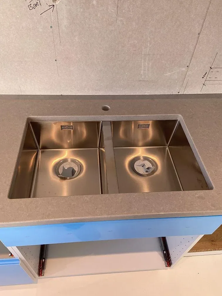 Underlimmad dubbel rostfri diskho i en köksbänkskiva av Technistone Noble Concrete Grey i Åkarp.