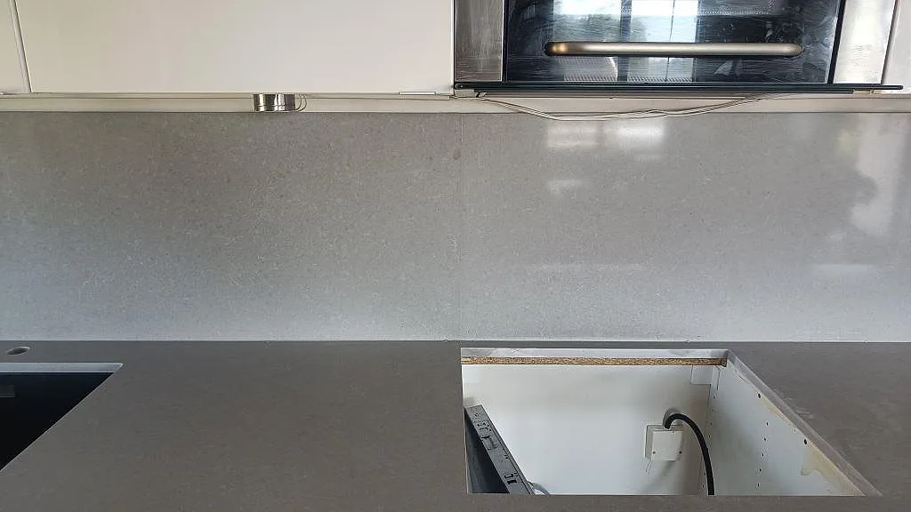 Matt grå köksbänkskiva i Technistone Noble Concrete Grey komposit med diskhoområde och hög stänkpanel i Asmundtorp.