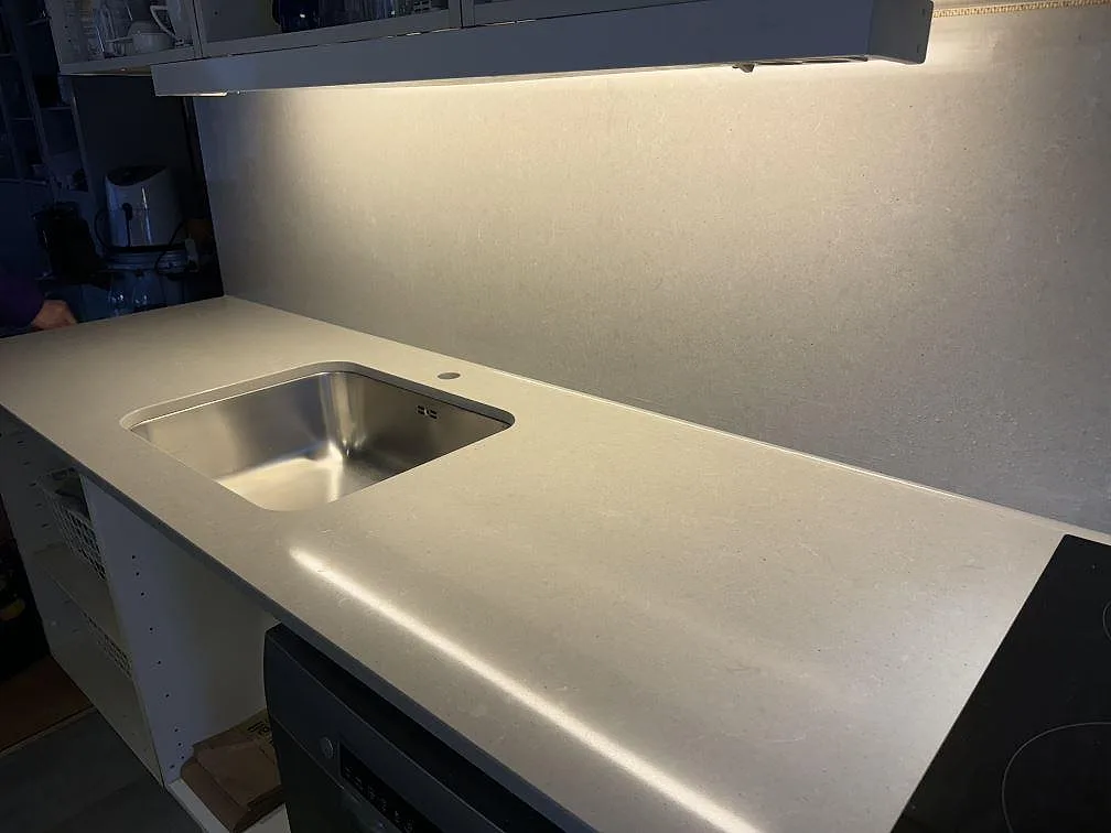 Köksbänkskiva i polerad Technistone Noble Concrete Grey med underlimmad rostfri diskho, stänkskydd och häll i Båstad.