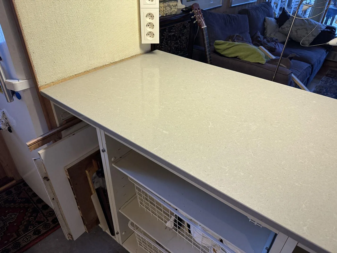 Närbild på halvö i polerad Technistone Noble Concrete Grey, kvartskomposit, med ljus stenstruktur i ett kök i Båstad.