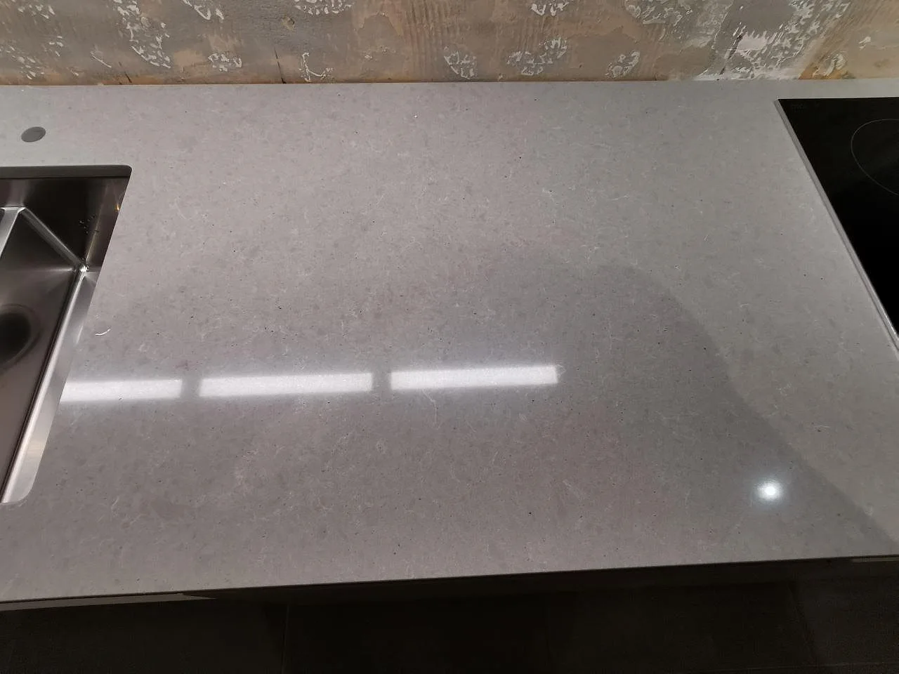 Grå betonglik köksbänkskiva i Technistone Noble Concrete Grey med diskho och plats för häll, polerad yta, i ett kök i Bjärred.