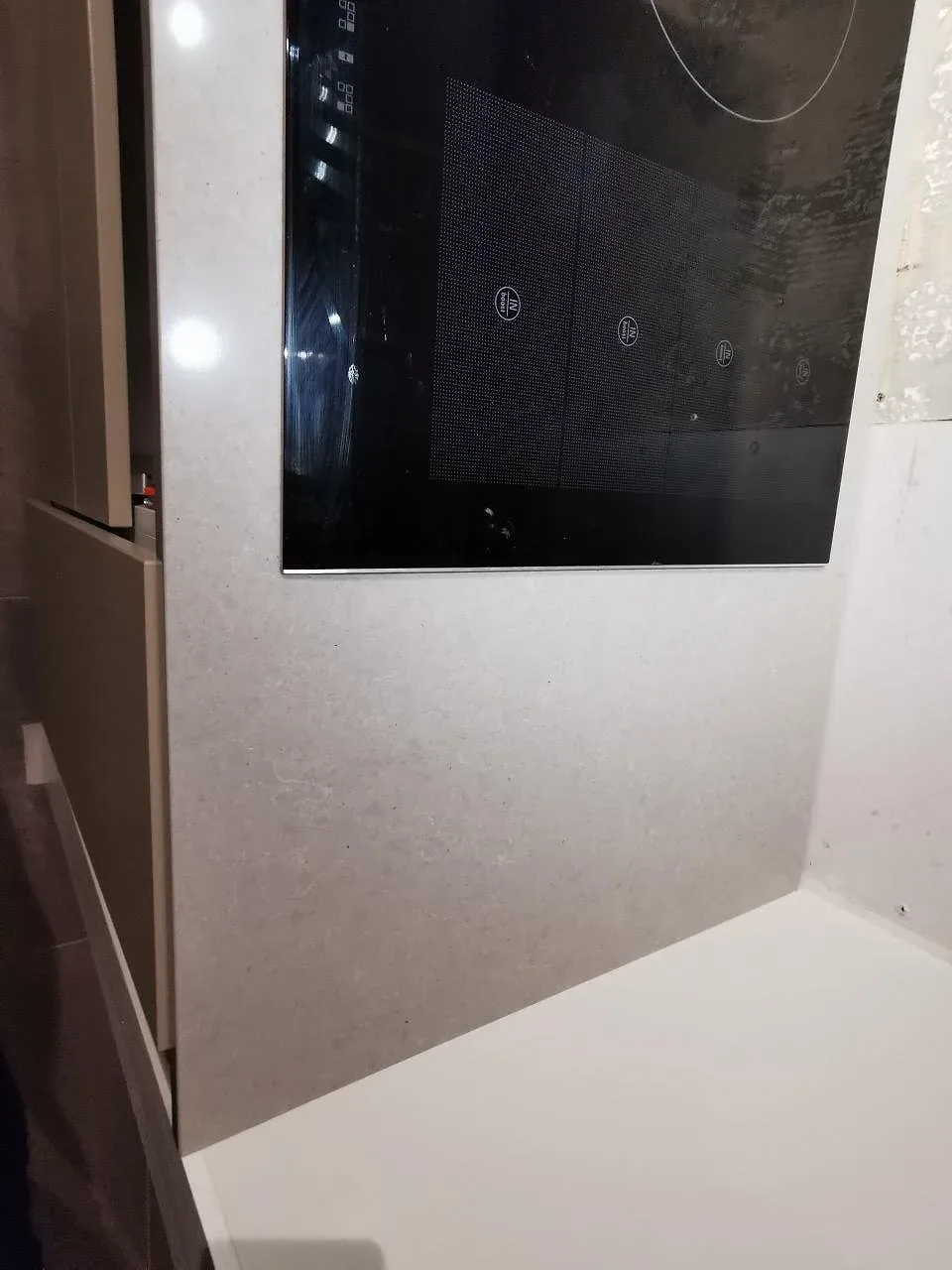 Köksbänkskiva i grå Technistone Noble Concrete Grey med induktionshäll, polerad kvartskomposit, i ett kök i Bjärred.