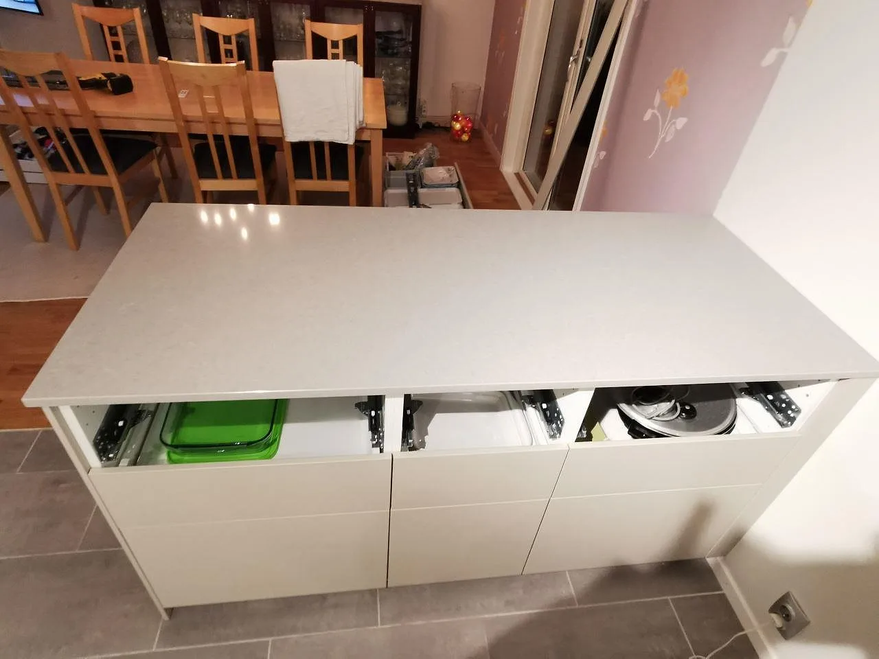 Köksö i grå polerad Technistone Noble Concrete Grey sedd ovanifrån mot matplatsen i ett kök i Bjärred.