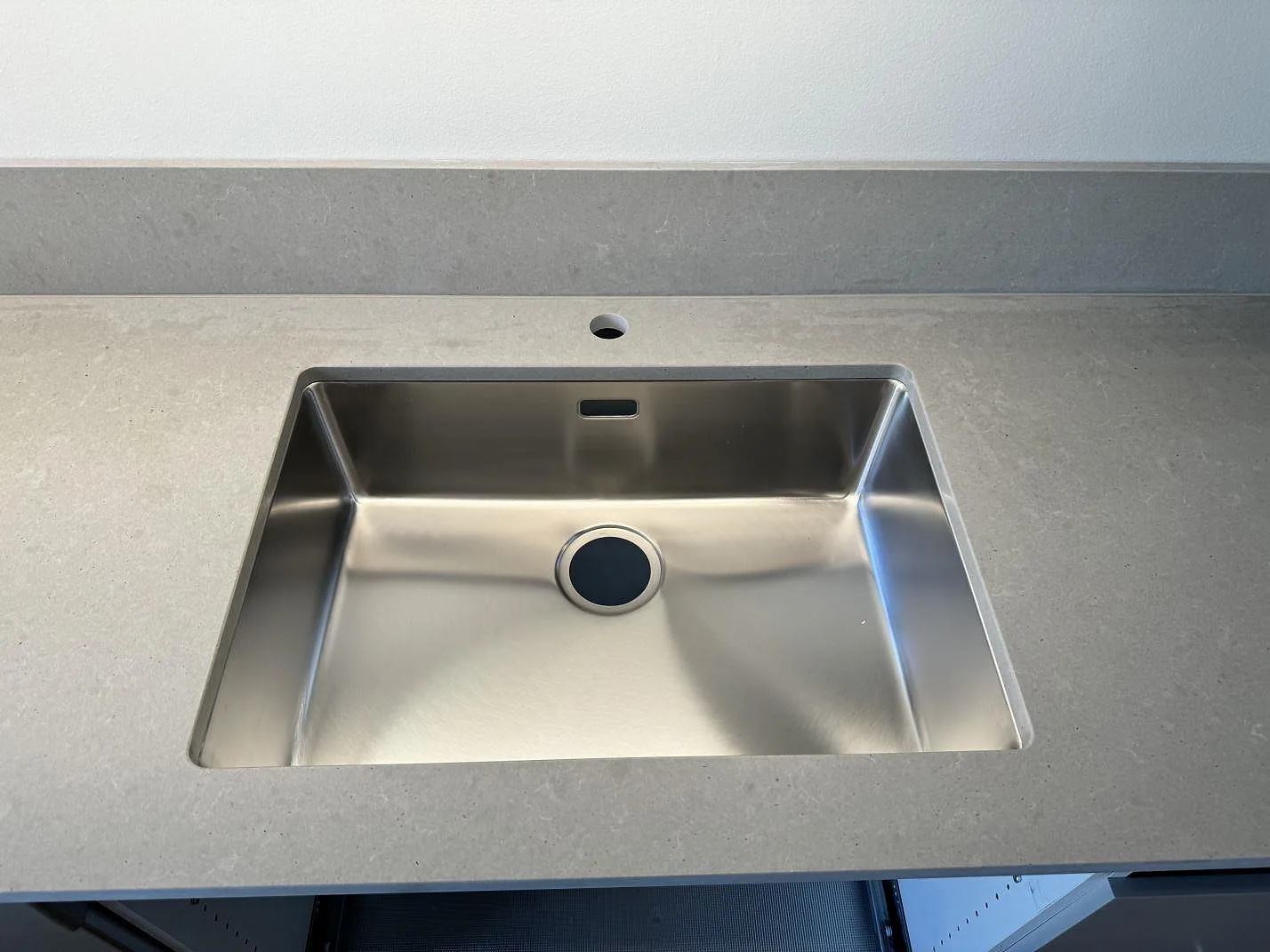 Underlimmad rostfri diskho i matt Technistone Noble Concrete Grey med förborrat hål för blandare i ett kök i Göteborg.