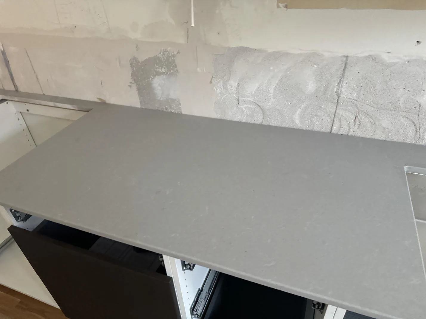 Ytdetalj av grå matt Technistone Noble Concrete Grey som köksbänkskiva på öppna köksstommar i Göteborg.