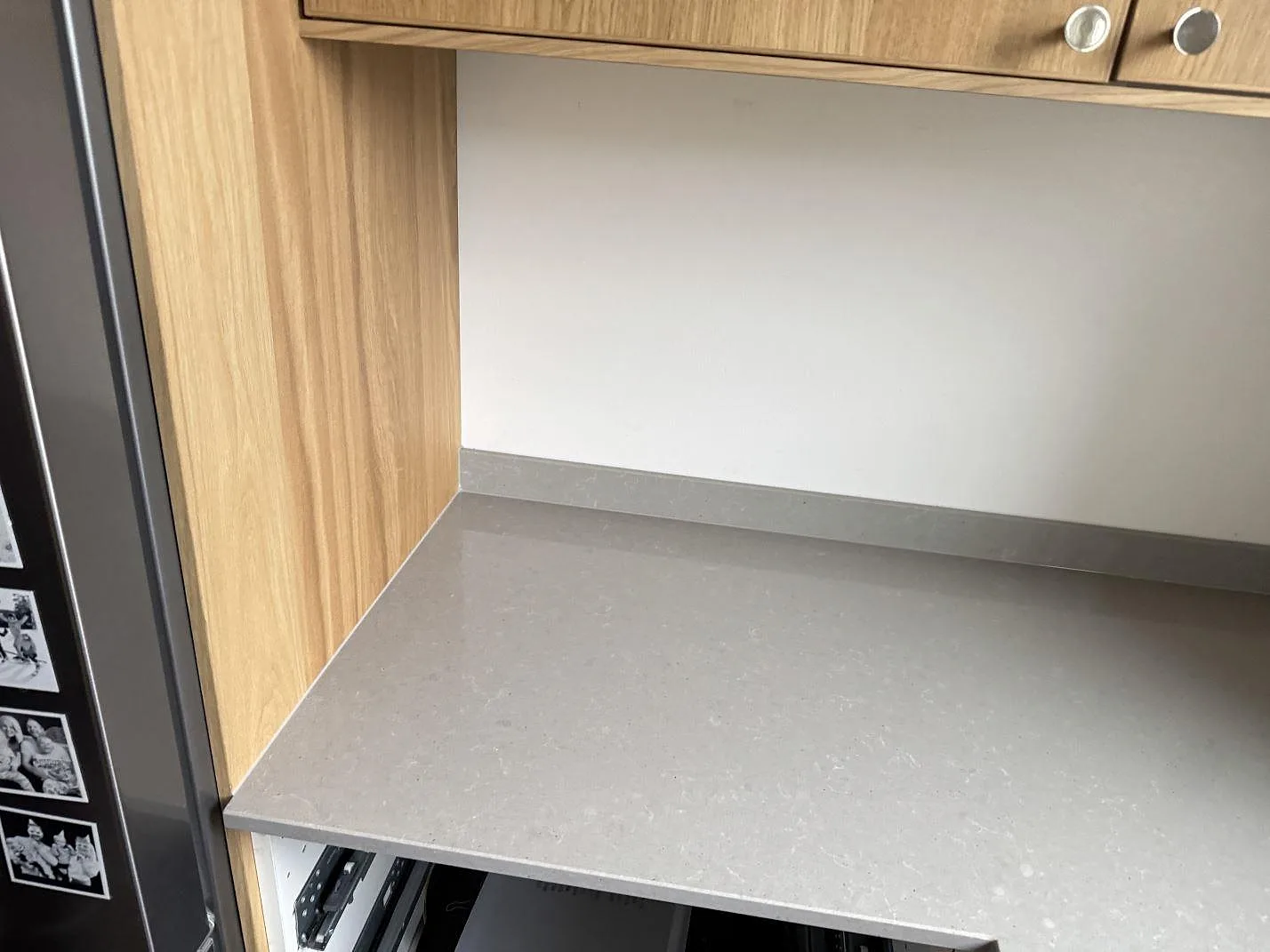 Bänkskiva i betonggrå Technistone Noble Concrete Grey mellan kyl och ekstommar i ett kök i Jönköping.