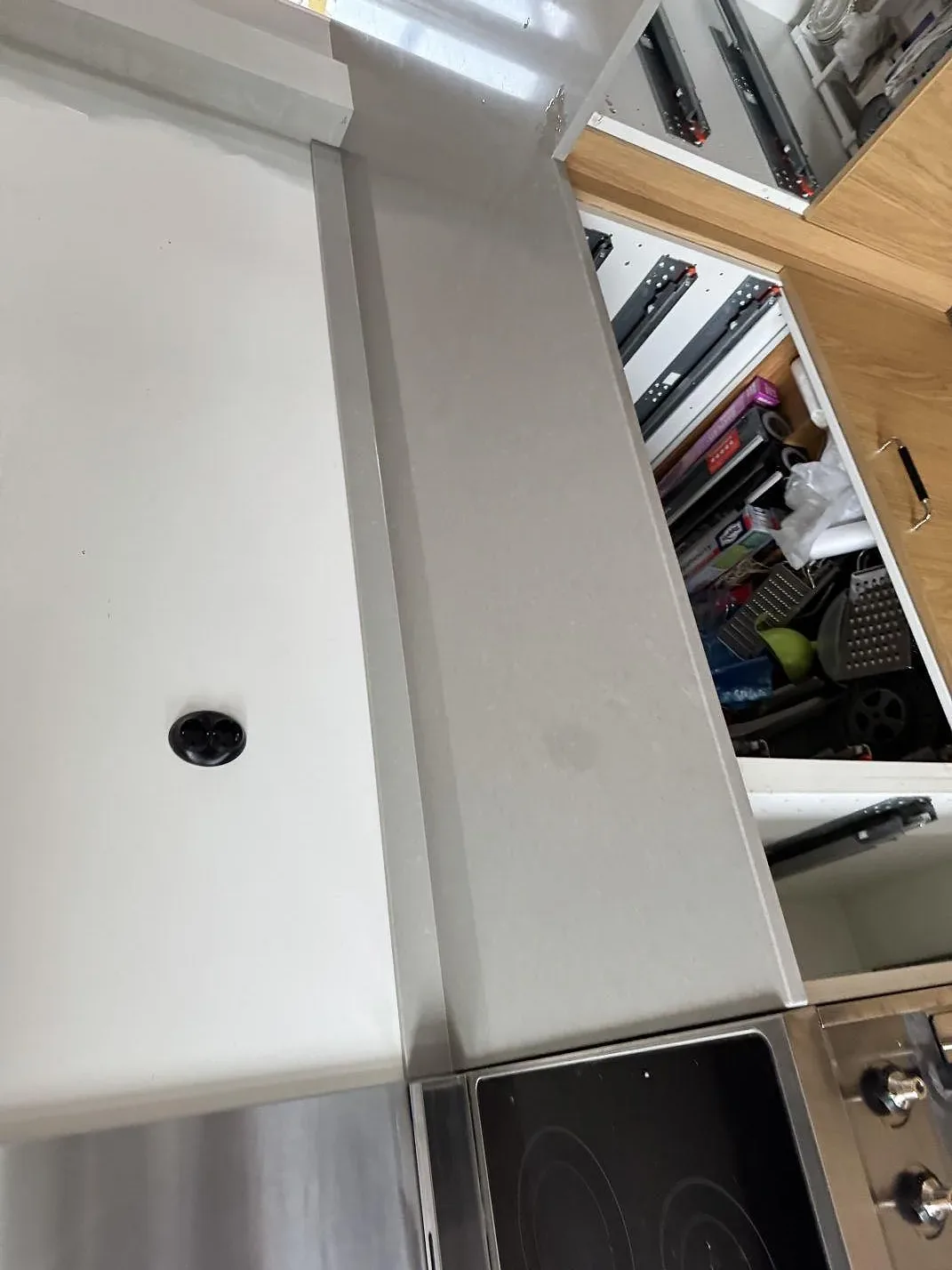 Köksbänk i polerad Technistone Noble Concrete Grey som löper förbi en fristående spis med glaskeramikhäll i ett kök i Jönköping.