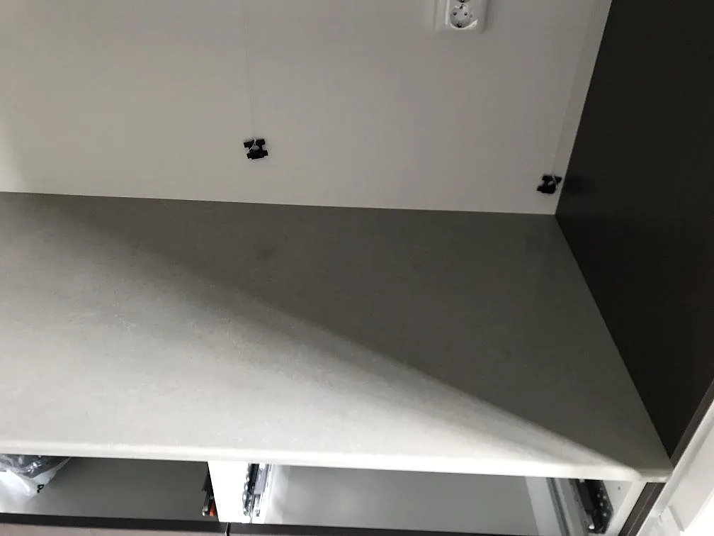 Hörn av den grå Technistone Noble Concrete Grey-bänkskivan i komposit i ett kök i Kågeröd, fotat under montering.