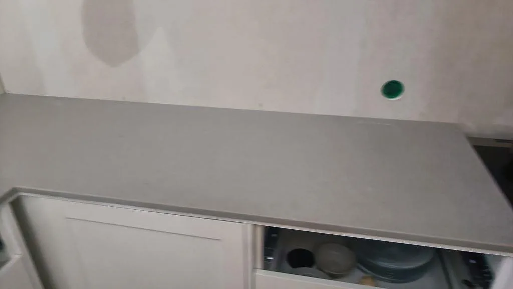 Rak bänkskiva i matt Technistone Noble Concrete Grey längs väggen med öppna köksstommar i Limhamn.
