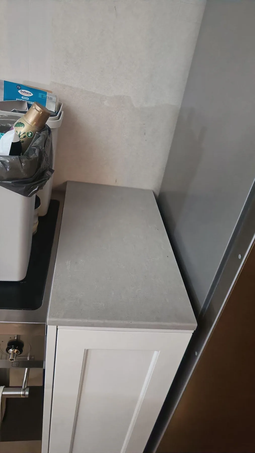Kort avslutande köksbänkskiva i matt Technistone Noble Concrete Grey bredvid spis och vägg i Limhamn.