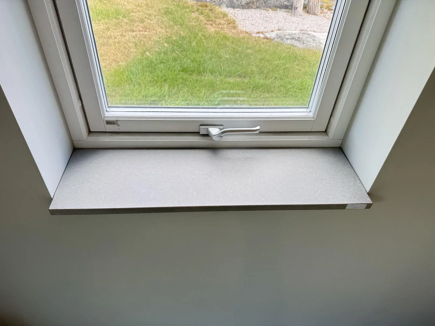 Närbild av fönsterbänk i matt Technistone Noble Concrete Grey med grå betonglik yta i Listerby.