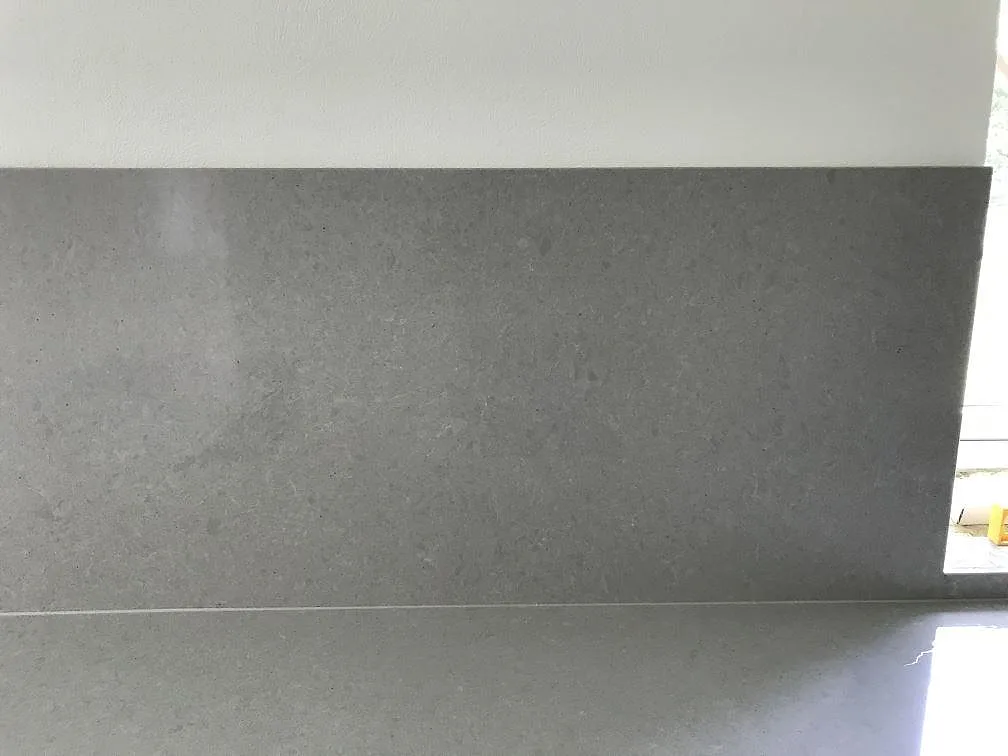 Köksbänkskiva och stänkskydd i grå Technistone Noble Concrete Grey, polerad, i hörnet av ett kök i Löberöd.