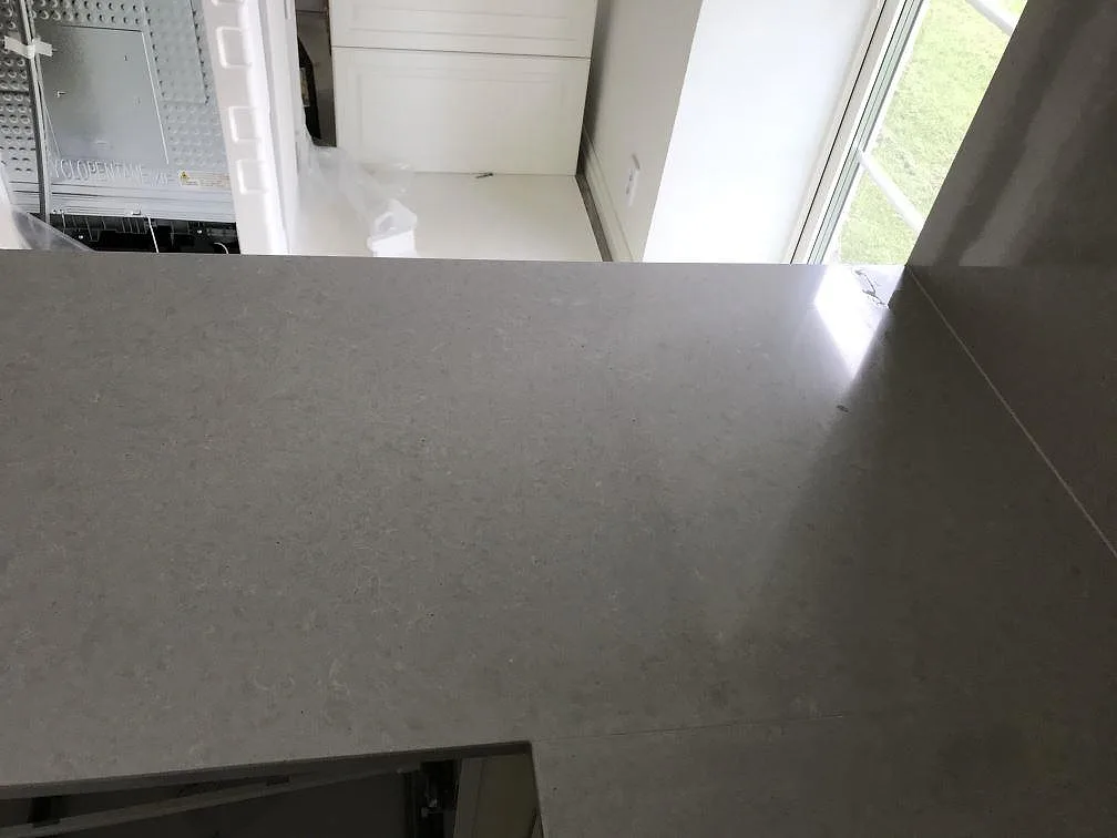 Köksbänkskiva i polerad Technistone Noble Concrete Grey sedd ovanifrån med fönsterljus och betongtonad yta i ett kök i Löberöd.