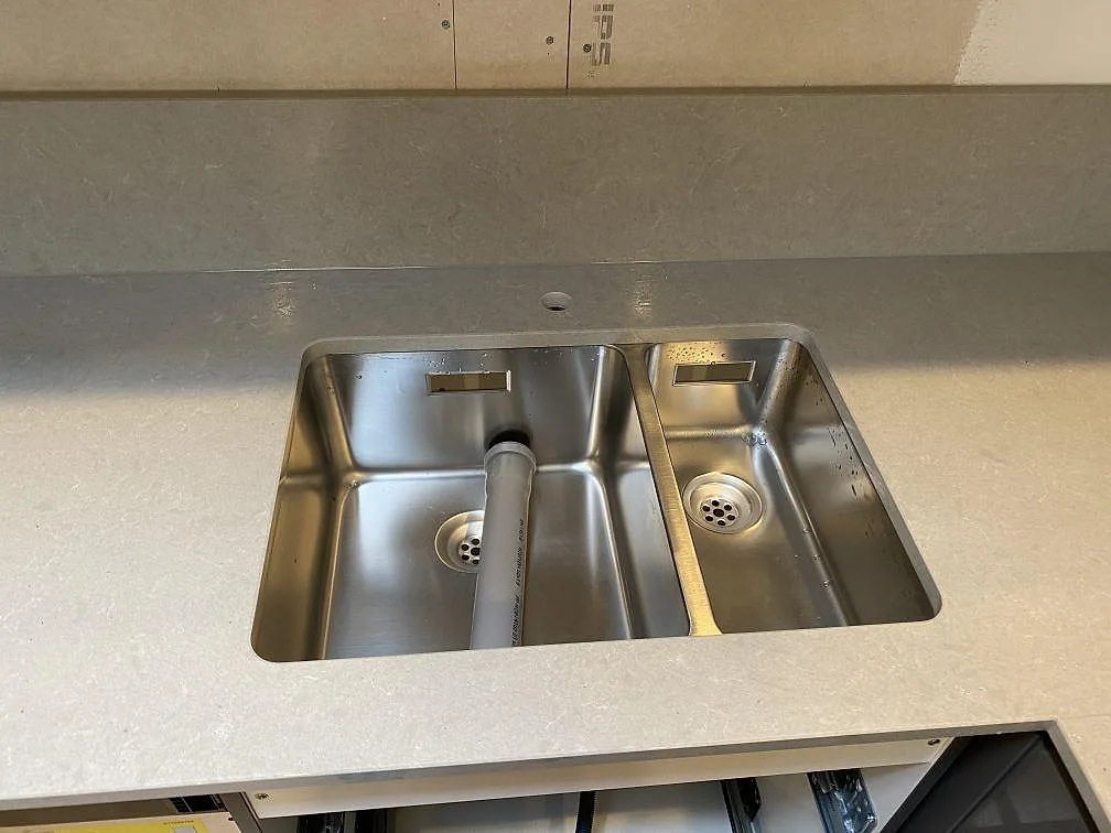 Underlimmad rostfri diskho med 1,5 ho i en ljusgrå Technistone Noble Concrete Grey bänkskiva i ett kök i Lund.