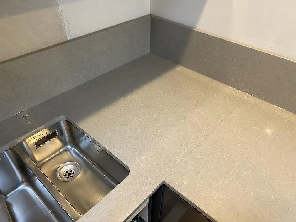 Närbild på underlimmad rostfri 1,5-hos diskho i en ljusgrå Technistone Noble Concrete Grey bänkskiva i ett kök i Lund.