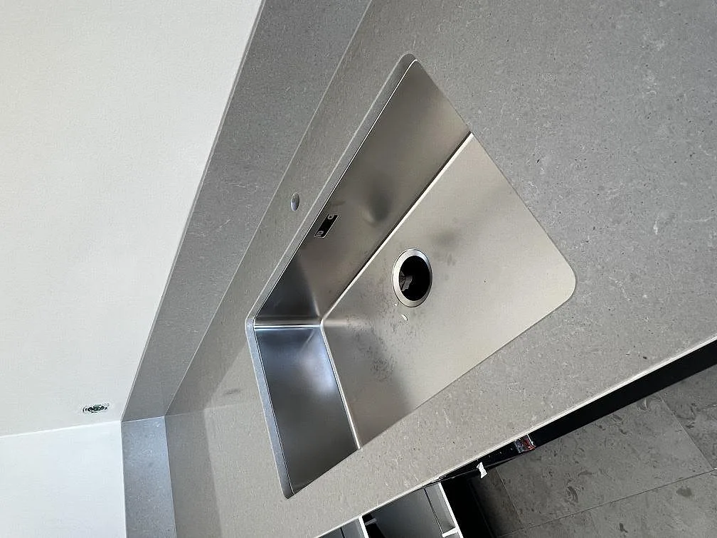 Underlimmad rostfri diskho i grå Technistone Noble Concrete Grey köksbänkskiva i Lund.