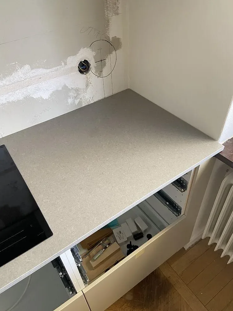 Detalj av grå köksbänkskiva i Technistone Noble Concrete Grey, matt kvartskomposit, vid häll och vägg i Malmö.