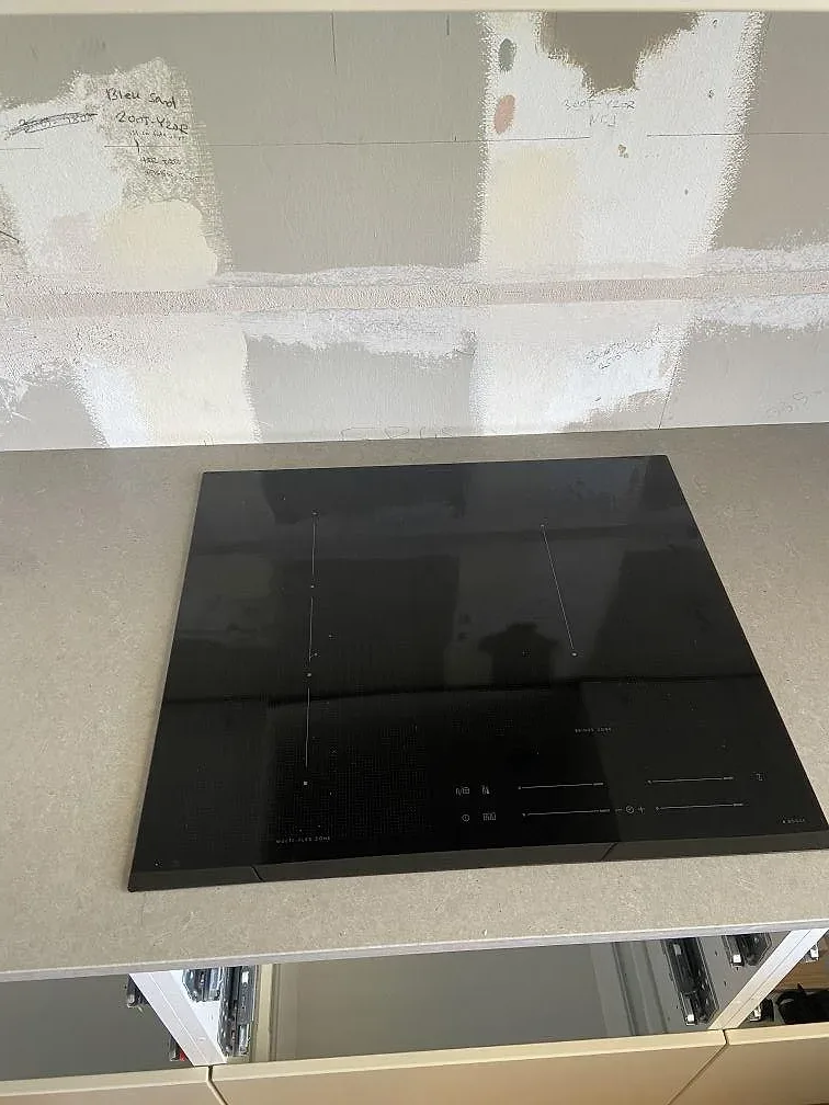 Ovanifrån syns svart häll i en matt köksbänkskiva av Technistone Noble Concrete Grey i Malmö.