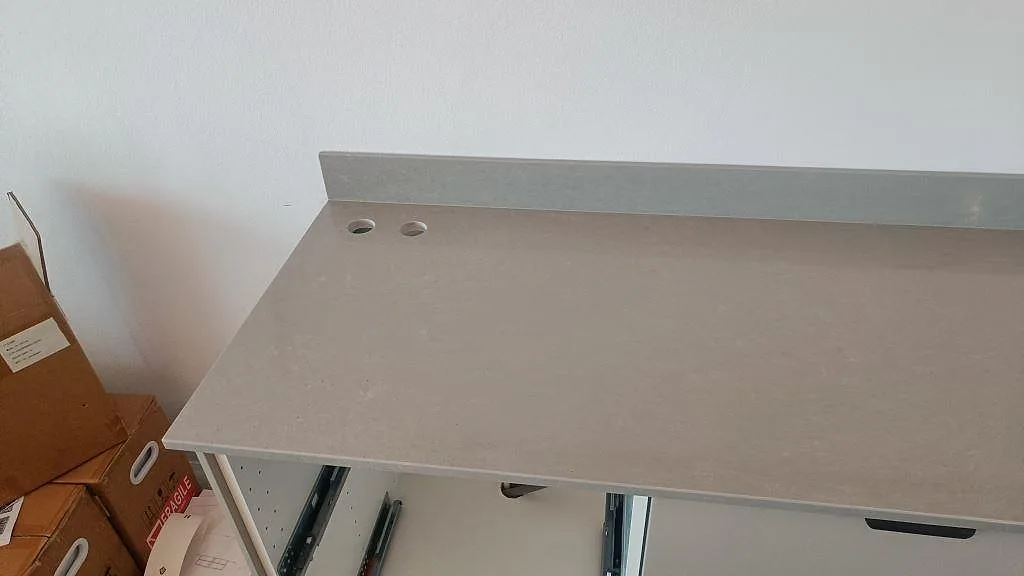 Detalj av polerad Technistone Noble Concrete Grey bänkskiva med stänkskydd och hål för blandare i Malmö.