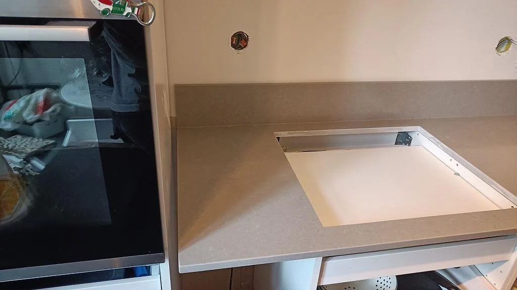 Förberedd hällöppning i en polerad köksbänkskiva av Technistone Noble Concrete Grey med uppvikt stänkskydd i Malmö.