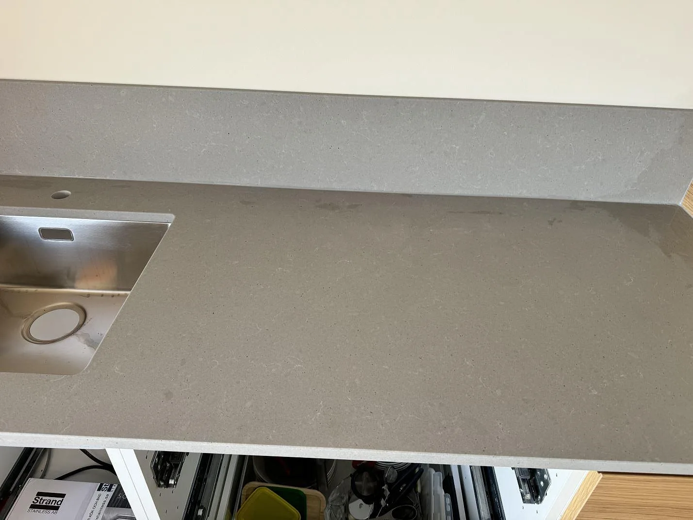 Rak väggbänk i matt Technistone Noble Concrete Grey komposit med rostfri diskho, blandarhål och uppvikt stänkskydd i Mölndal.
