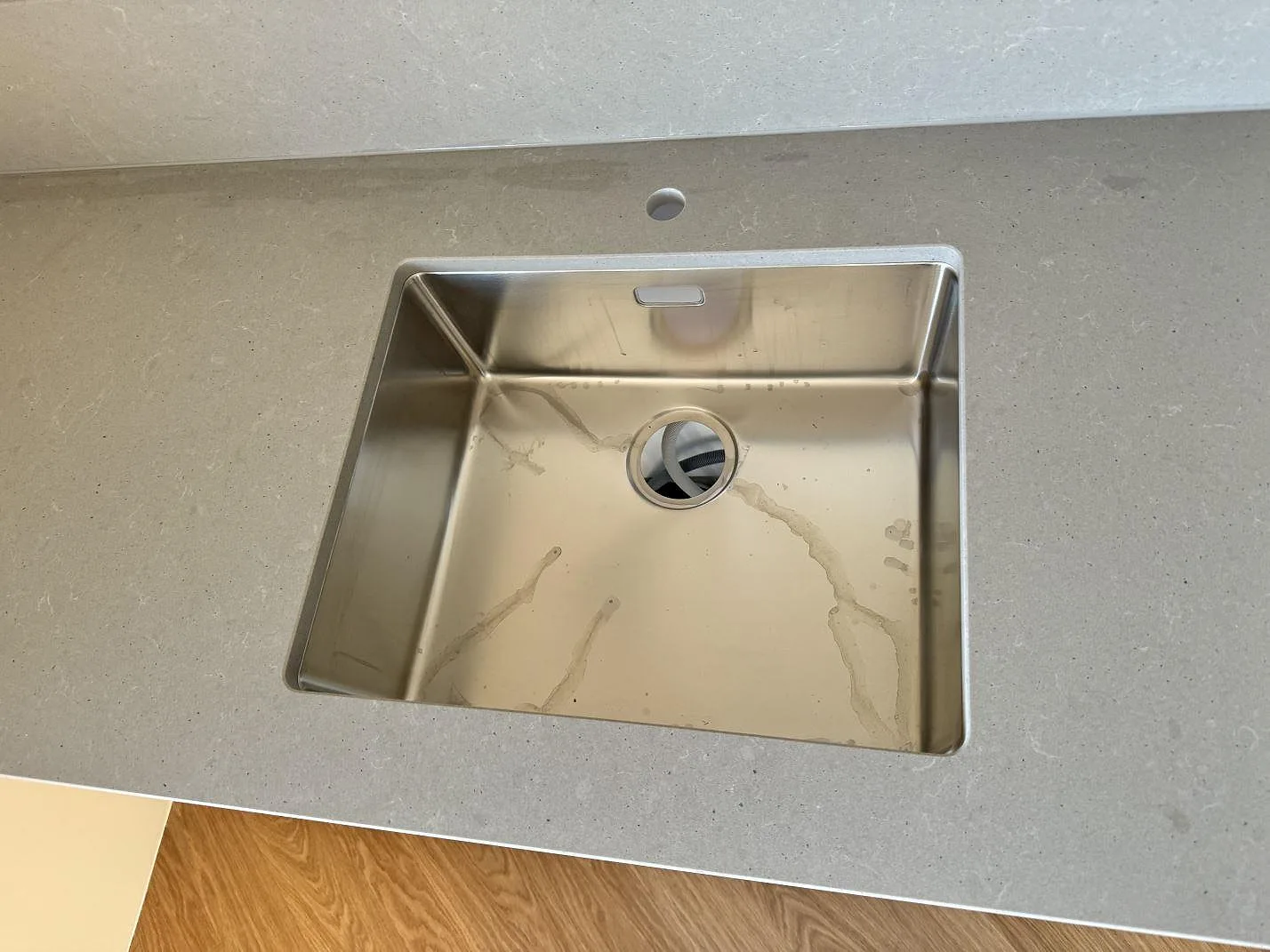 Rostfri diskho i en matt Technistone Noble Concrete Grey köksbänkskiva med grå kvartskomposit och stänkskydd i Mölndal.