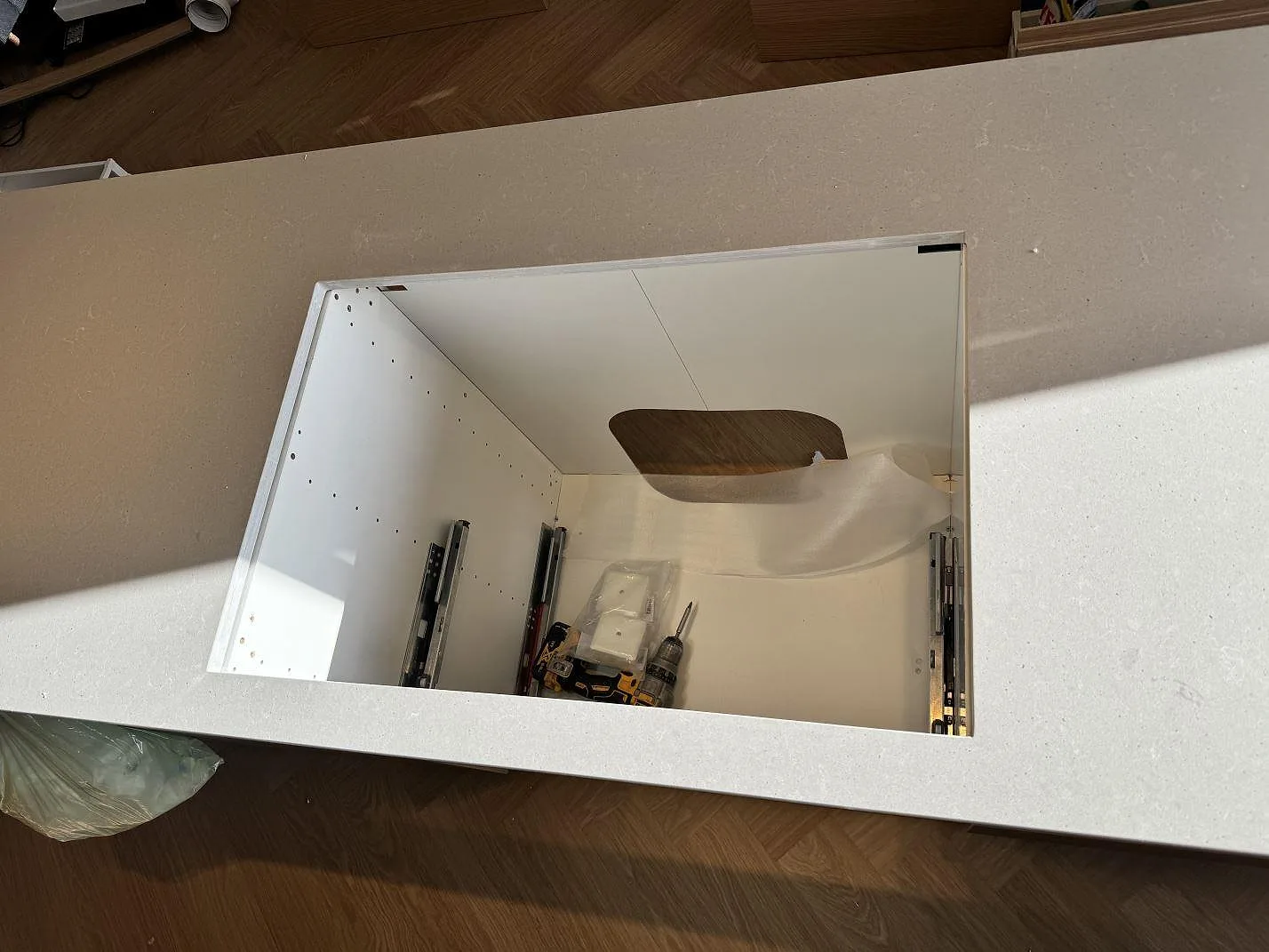 Top-down av stor urtagning i en matt Technistone Noble Concrete Grey köksbänkskiva på öppna köksstommar i Mölndal.