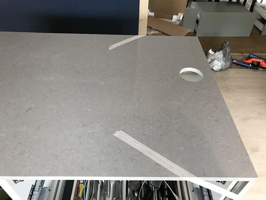 Polerad bänkskiva i Technistone Noble Concrete Grey ovanifrån med kranhål under montering i ett kök i Tygelsjö.