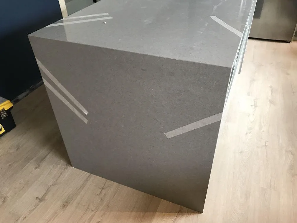 Köksö i grå Technistone Noble Concrete Grey med polerad yta och vattenfallskant fotograferad under montering i Tygelsjö.