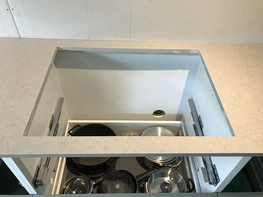 Köksbänkskiva i Technistone Noble Concrete Grey med urtag och utdragslådor under bänken i ett kök i Tygelsjö.