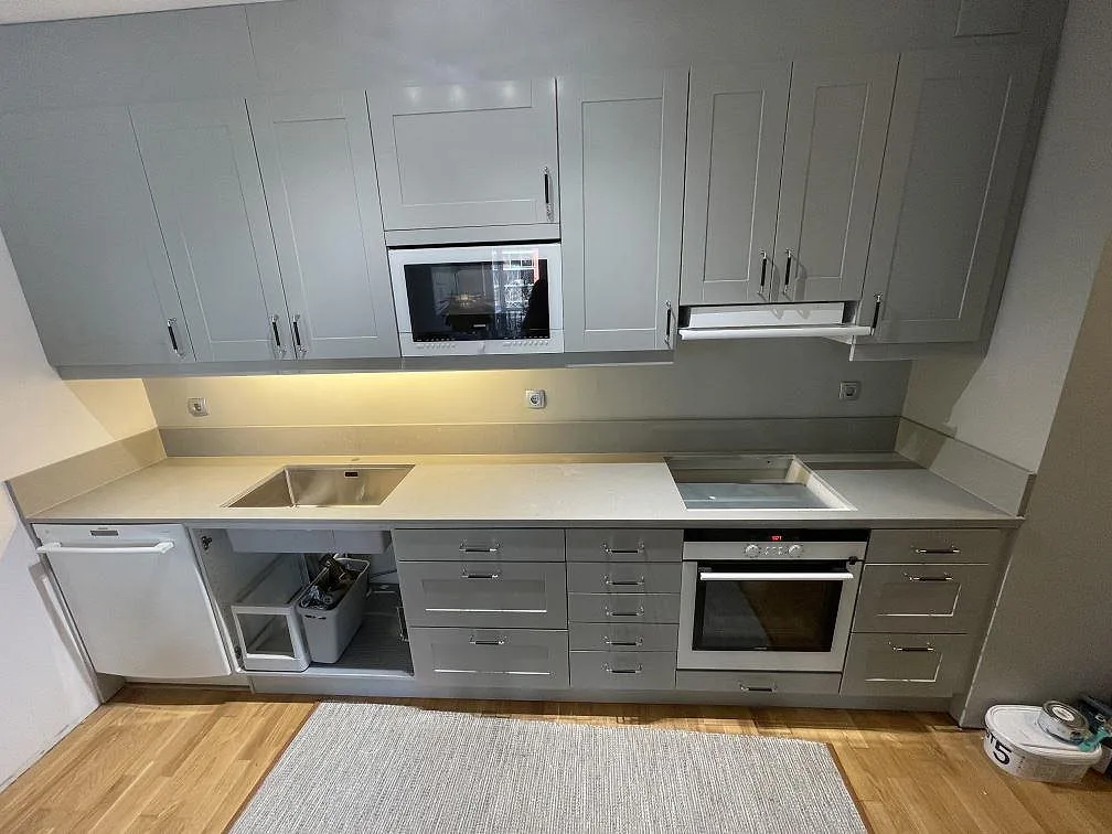 Köksbänkskiva i grå Technistone Noble Concrete Grey, polerad kvartskomposit, med diskho och hällzon i ett kök i Västerås.