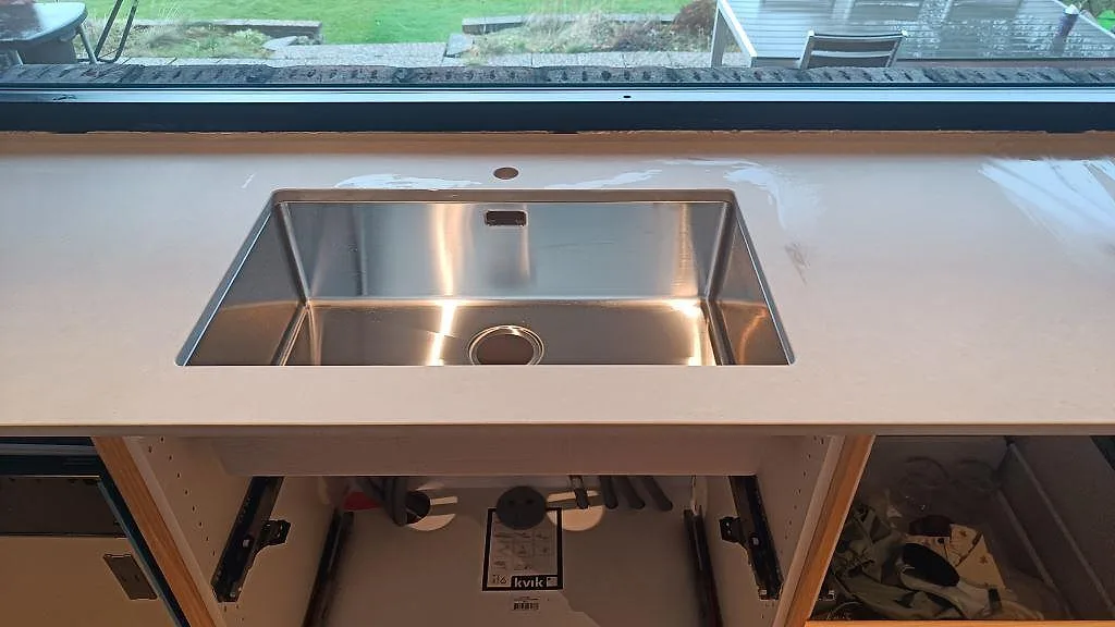 Detalj av matt Technistone Noble Concrete Grey runt en rostfri diskho vid fönstret i köket i Västra Frölunda.