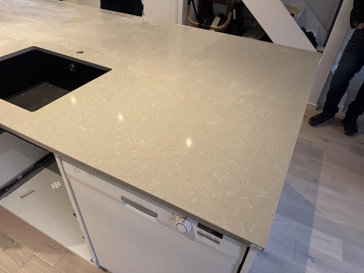 Närbild av polerad Technistone Noble Concrete Grey som köksbänkskiva med mörk diskho och ljus teckning i Västra Frölunda.