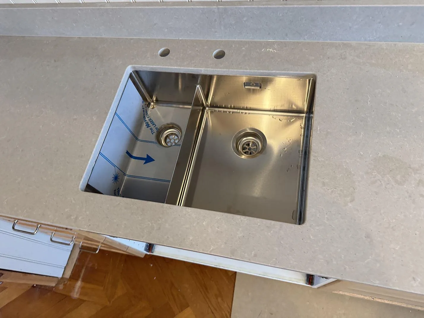 Underlimmad dubbel diskho i rostfritt stål infälld i en grå Technistone Noble Concrete Grey kompositbänkskiva i ett kök i Västra Frölunda.