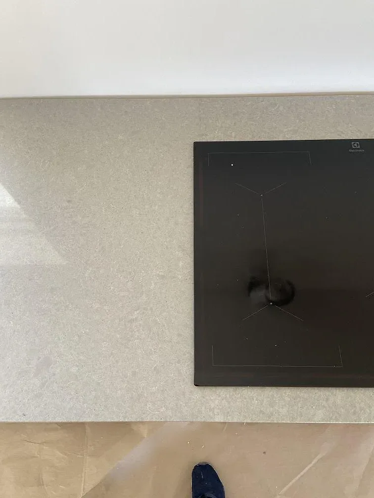 Infälld Electrolux induktionshäll i matt betonggrå Technistone Noble Concrete Grey bänkskiva i ett kök i Vellinge.