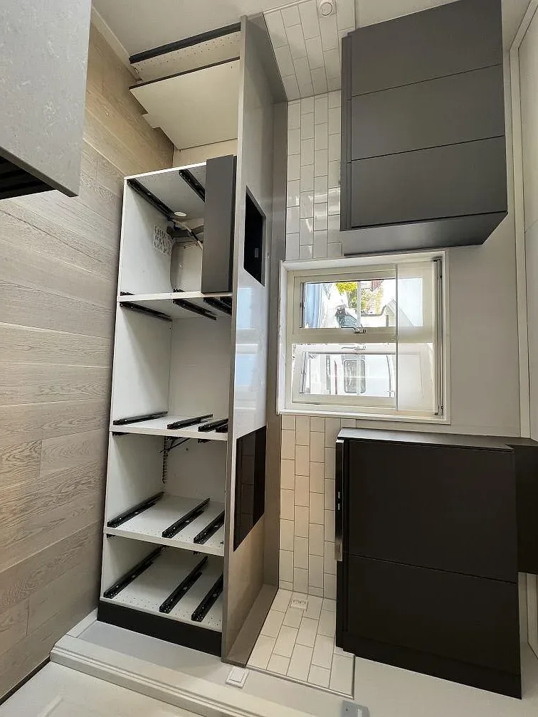 Koksö i ljusgra Technistone Noble Concrete Grey kvartskomposit med svart ribbad sockel, fotograferad under montering i ett kok i Vellinge.