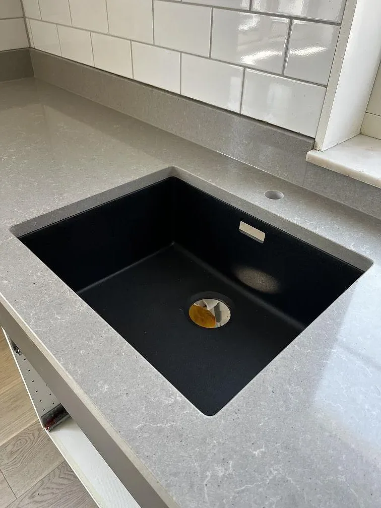 Underlimmad svart diskho i ljusgra Technistone Noble Concrete Grey bankskiva i ett kok i Vellinge.