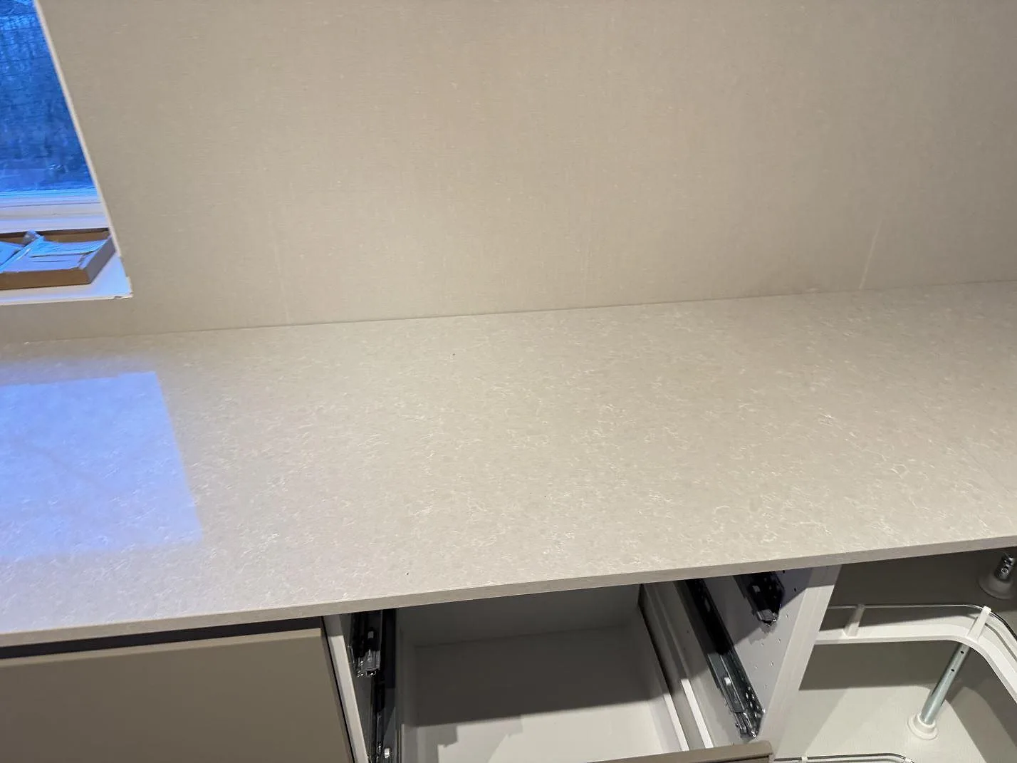 Rak köksbänk i polerad Technistone Noble Ivory White med låg stänkkant och ljus kvartskomposityta i Ängelholm.