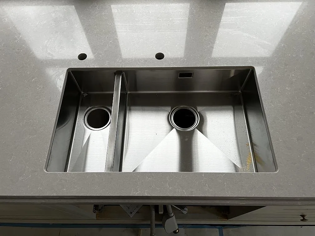 Dubbel underlimmad rostfri diskho monterad i polerad Technistone Noble Ivory White i köket i Barsebäck.