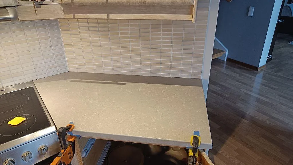 Installerad köksbänkskiva i Technistone Noble Ivory White, polerad kvartskomposit, med bred arbetsyta och kakel i Bjuv.