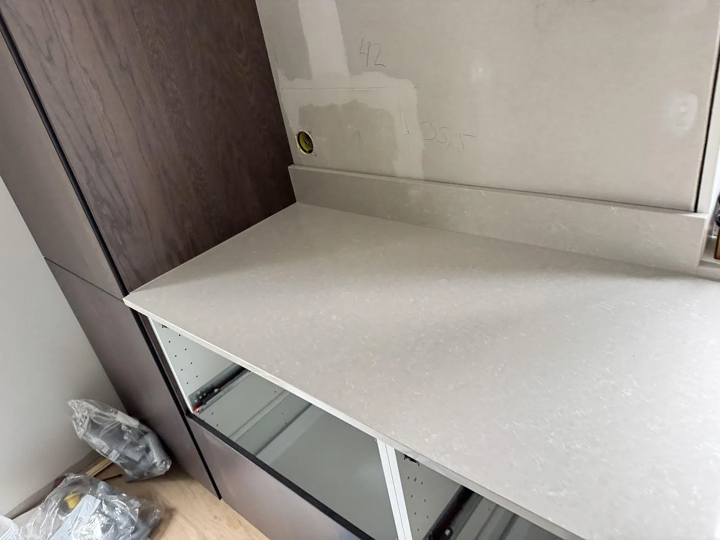 Sidovy av polerad Technistone Noble Ivory White komposit på köksbänk med uppvikt stänkkant och trästommar i Eksjö.