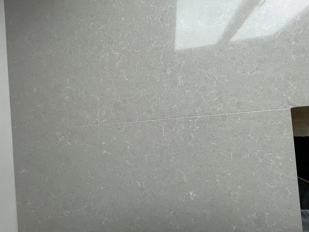 Narbild av den polerade ytan pa en koksbankskiva i Technistone Noble Ivory White, kvartskomposit i kramvit ton med diskret adring, i Enskede.