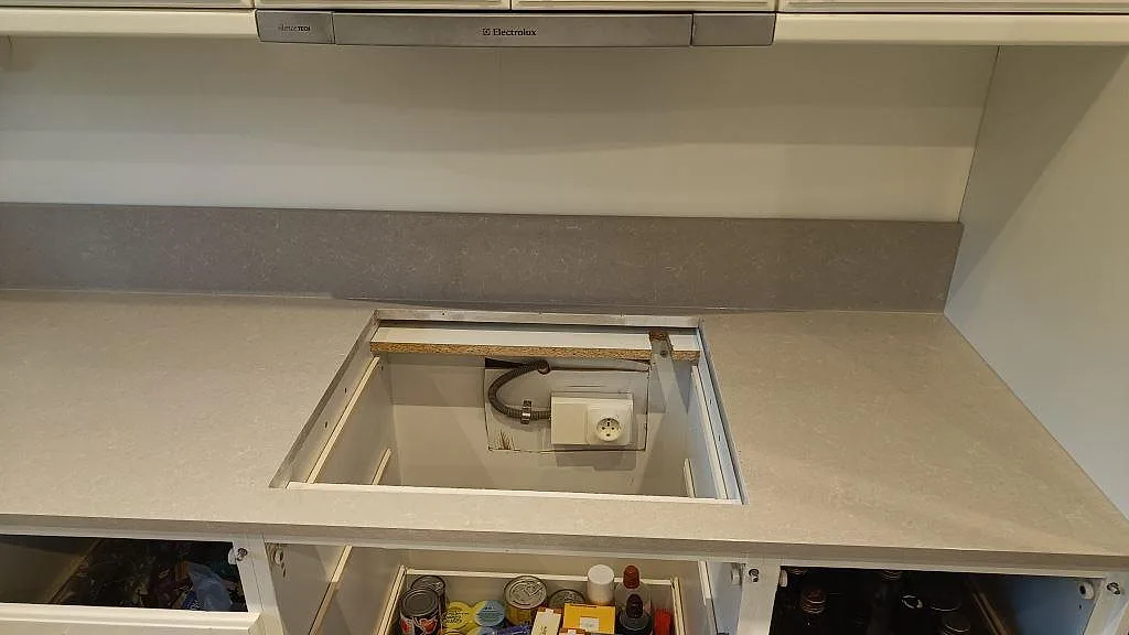 Förberedd hällöppning i en polerad köksbänkskiva av Technistone Noble Ivory White under fläktkåpa i Eslöv.