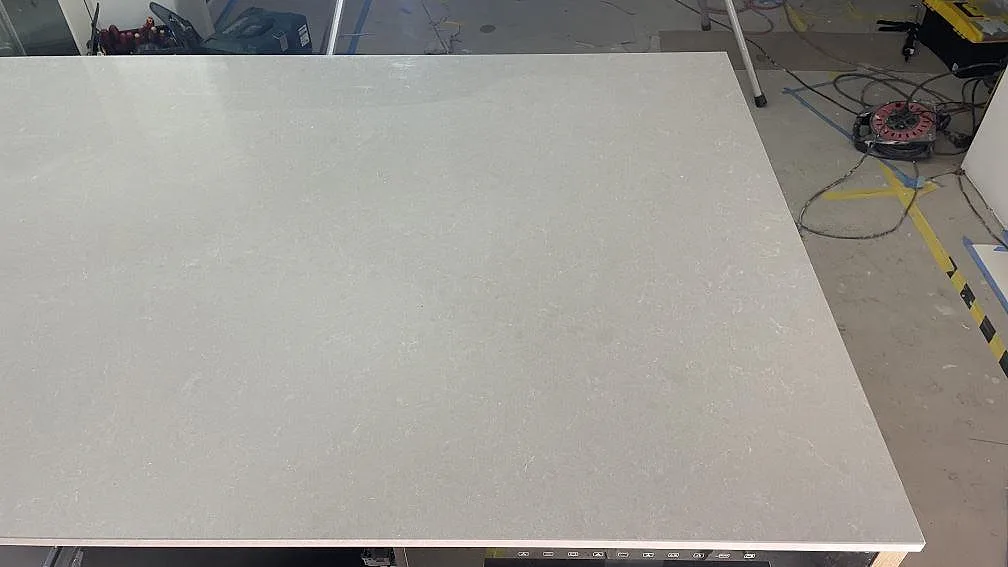 Stor polerad skivyta i Technistone Noble Ivory White på en köksö under montering i Frillesås.