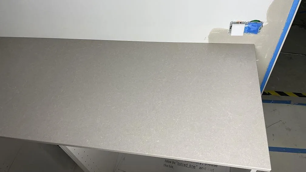 Rak bänkskiva i Technistone Noble Ivory White på ljusa köksstommar under montering i Frillesås.